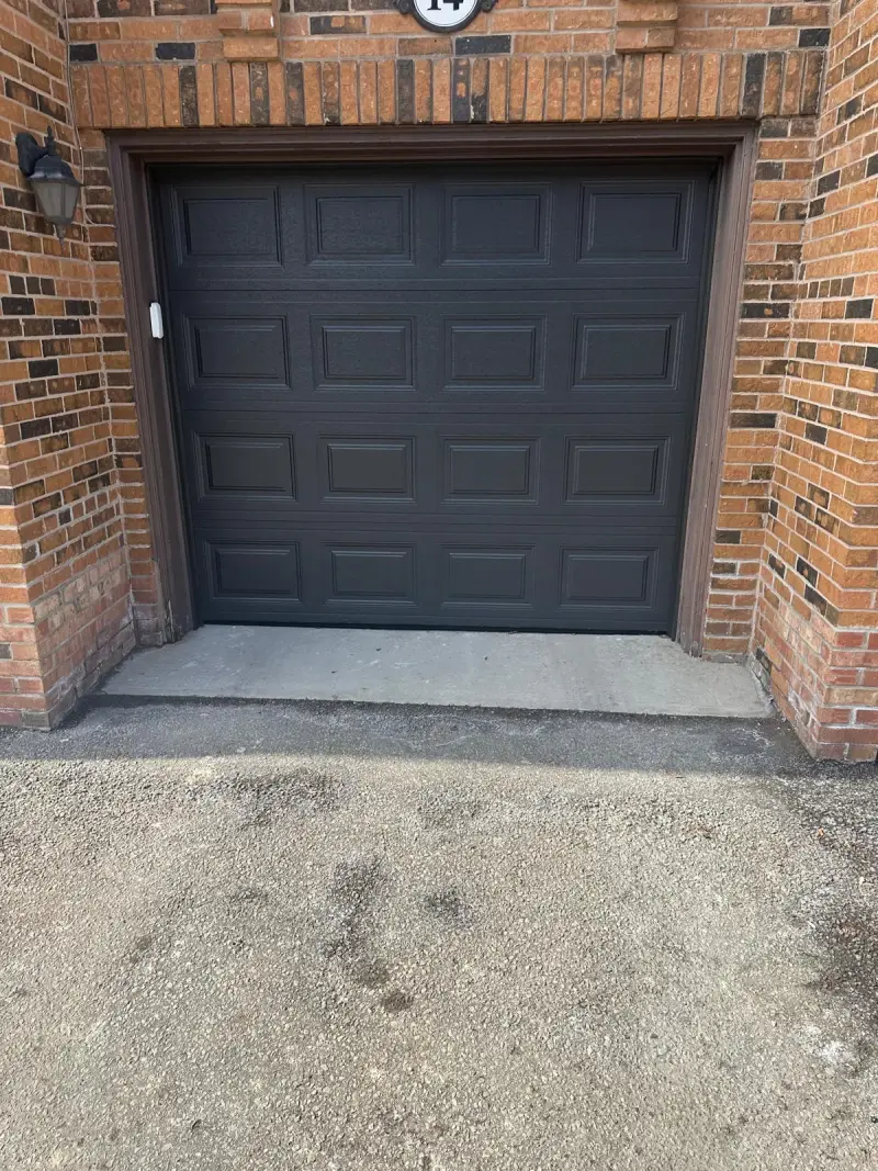 Modern full-view garage door glowing at dusk